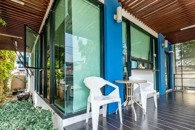 a porch with two white chairs and a table at Riski Residence Bangkok-noi - Wasit Apartment in Bangkok