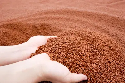 a person picking up a pile of grains of sand at The Square 101 in Bangkok