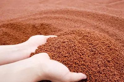 a person picking up a pile of grains of sand at The Square 101 in Bangkok