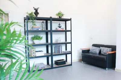 a black book shelf with plants and a couch at The Square 101 in Bangkok
