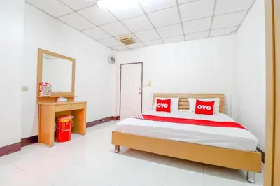 a bedroom with a bed with red pillows and a mirror at OYO 525 MRT Phetkasem 48 -1 Place in Bangkok