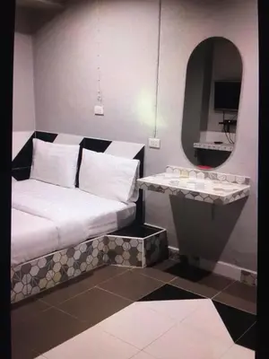 a room with a bed and a sink with a mirror at Benjamas hostels in Bangkok