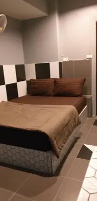 a bedroom with a bed with a checkered wall at Benjamas hostels in Bangkok