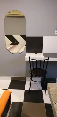 a room with a table and a chair and a mirror at Benjamas hostels in Bangkok