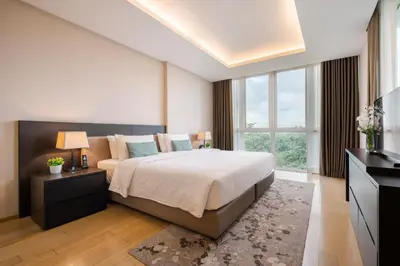 a bedroom with a large bed and a large window at North Park Serviced Apartment Bangkok in Bangkok