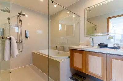 a bathroom with a shower and a sink and a tub at North Park Serviced Apartment Bangkok in Bangkok