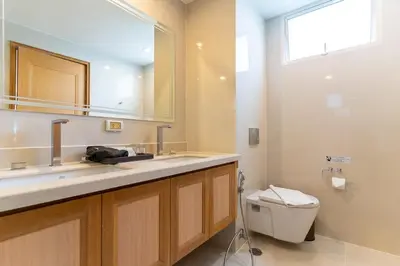 a bathroom with a toilet and a sink and a mirror at North Park Serviced Apartment Bangkok in Bangkok