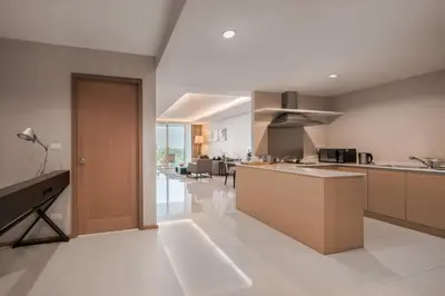 a large kitchen with a counter and a dining room at North Park Serviced Apartment Bangkok in Bangkok
