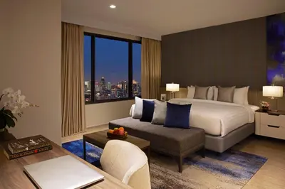 a hotel room with a bed and a couch at Somerset Rama 9 Bangkok in Bangkok