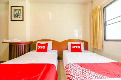 two beds in a room with two red pillows at OYO 583 Sweethome Guest House in Bangkok Noi
