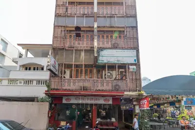 a tall building with a balcony on top of it at OYO 583 Sweethome Guest House in Bangkok Noi