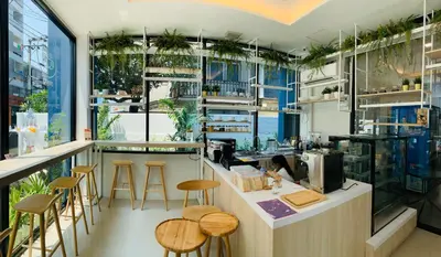 a restaurant with a counter and stools in a room at J & L Residence and Spa in Ban Khlong Khwang Klang