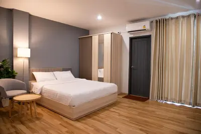 a bedroom with a bed and a chair and a table at J & L Residence and Spa in Ban Khlong Khwang Klang