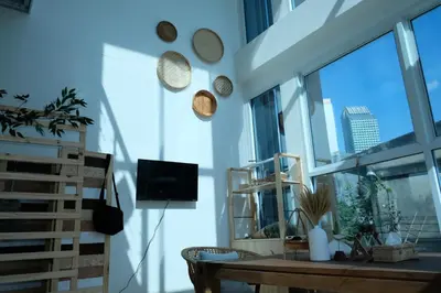 a living room with a table and a large window at Ratchada Hotel - ROTFAI in Bangkok