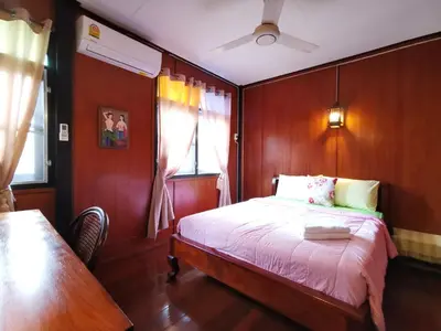 a bedroom with a bed and a table in it at TAVEE Guesthouse in Bangkok