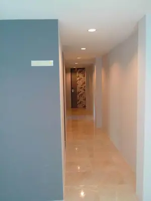 a hallway with a blue wall and a hallway with a wine cellar at Nantra Ploenchit hotel in Bangkok