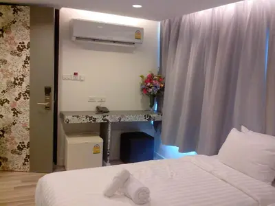 a hotel room with a bed and a desk at Nantra Ploenchit hotel in Bangkok