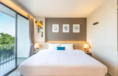 a bedroom with a large white bed and a balcony at 56 Hotel in Bangna
