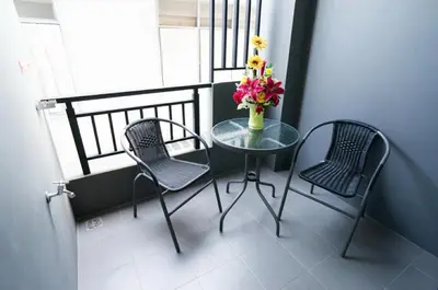 a table and two chairs and a vase of flowers on a balcony at DB PLUS 6 in Bangkok