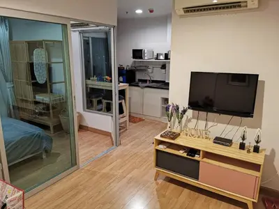 a living room with a flat screen tv and a table at Ekkamai+Thong Lor in Bangkok