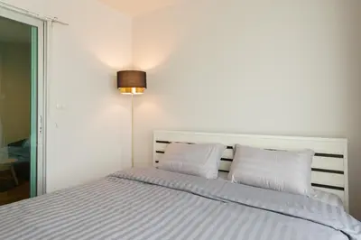 a white bed with two pillows in a bedroom at Ekkamai+Thong Lor in Bangkok