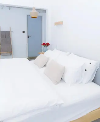 a white bed with white pillows in a bedroom at Ratchada Retreat Boutique Villa 1 in Bangkok