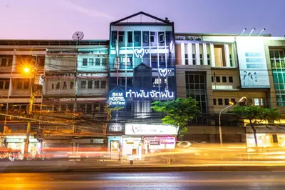 a city at night with traffic in front of buildings at Baan Kun Mhor Hostel บ้านคุณหมอโฮสเทล in Bangkok