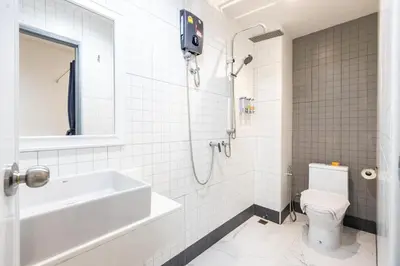 a bathroom with a shower and a sink and a toilet at Baan Kun Mhor Hostel บ้านคุณหมอโฮสเทล in Bangkok