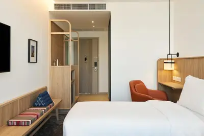a hotel room with a bed and a chair at ASAI Bangkok Chinatown in Bangkok