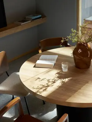 a wooden table with a book and a plant on it at ASAI Bangkok Chinatown in Bangkok