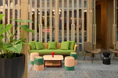 a living room with a green couch and a table at ASAI Bangkok Chinatown in Bangkok