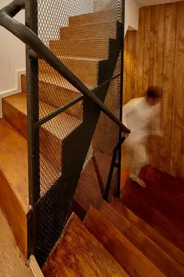 a person walking down a staircase with a metal railing at Livinn91 Hotel in Bangkok