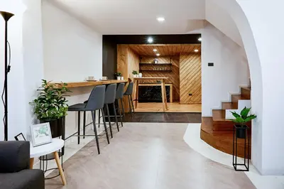 a kitchen and living room with a bar and stools at Livinn91 Hotel in Bangkok