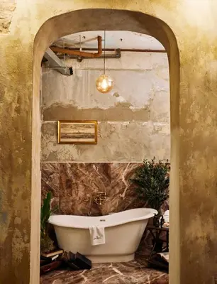 a bath tub in a bathroom with a stone wall at The Mustang Blu in Bangkok