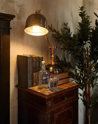 a lamp on top of a wooden table with books at The Mustang Blu in Bangkok