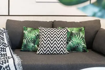 a couch with a bunch of pillows on it at MIQ Asoke202 Pool Villa - Asoke BTS 16 Pax in Bangkok