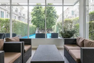 a room with chairs and a large window with a pool at MIQ Asoke202 Pool Villa - Asoke BTS 16 Pax in Bangkok