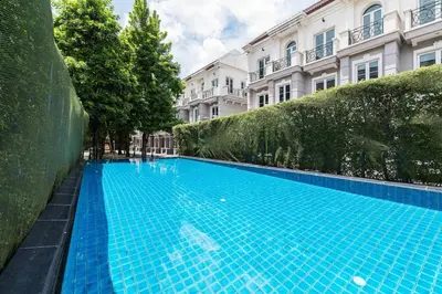 a large blue swimming pool in front of a building at MIQ Asoke202 Pool Villa - Asoke BTS 16 Pax in Bangkok