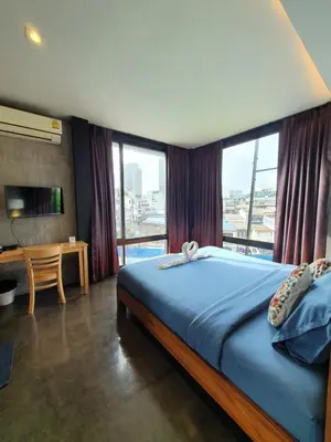 a bedroom with a bed with a large window at Baan Wualamphong บ้านวัวลำพอง in Bangkok