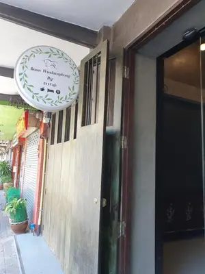 a sign for a restaurant on the side of a building at Baan Wualamphong บ้านวัวลำพอง in Bangkok