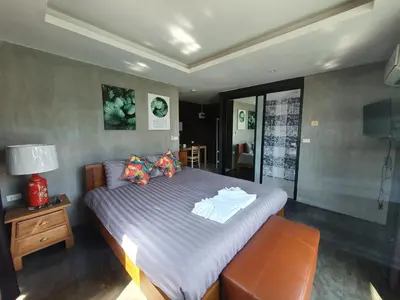 a bedroom with a bed with purple sheets and a television at Baan Wualamphong บ้านวัวลำพอง in Bangkok