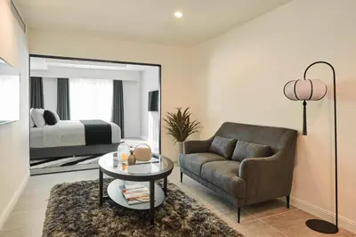 a living room with a couch and a table and a bed at Villa De Pranakorn in Bangkok