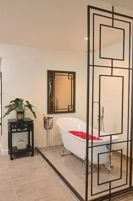 a bath tub in a bathroom with a mirror at Villa De Pranakorn in Bangkok