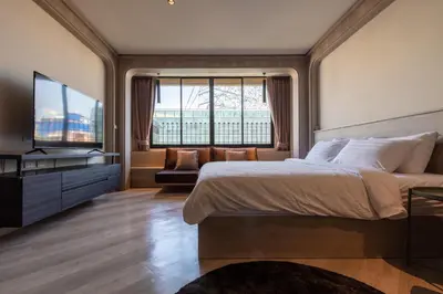 a bedroom with a large bed and a large window at The Spades Private Residence in Bangkok
