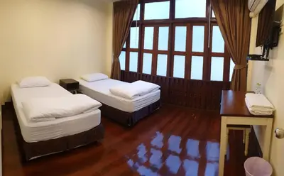 a room with two beds and a desk and a window at Papermoon Guesthouse in Bangkok