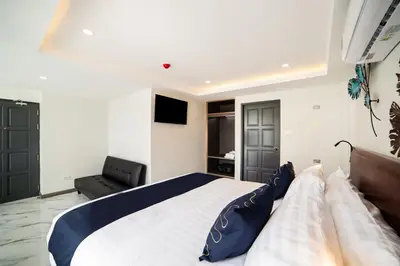 a bedroom with a large bed and a couch at RoomQuest Sukhumvit36 BTS Thonglor in Bangkok