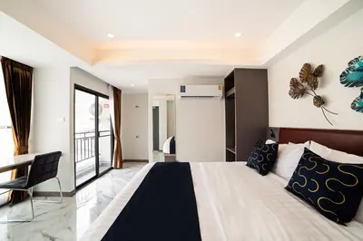 a bedroom with a large bed and a chair at RoomQuest Sukhumvit36 BTS Thonglor in Bangkok