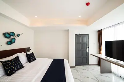 a bedroom with a bed and a flat screen tv at RoomQuest Sukhumvit36 BTS Thonglor in Bangkok