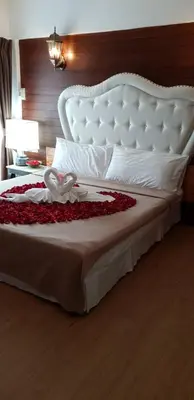 a large bed with a white headboard and roses on it at @42 Residence in Bangkok