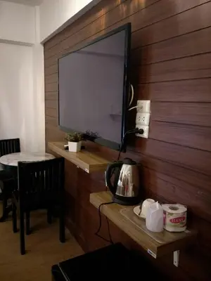 a flat screen tv on a wooden wall with a table at @42 Residence in Bangkok